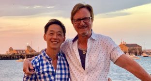 AJ Shepard and Anthony Chiu stand in front of an ocean at sunset