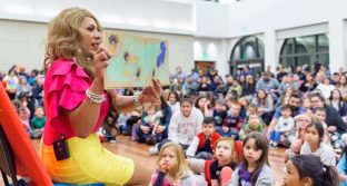 Bella Aldama reads to a crowd of children and adults